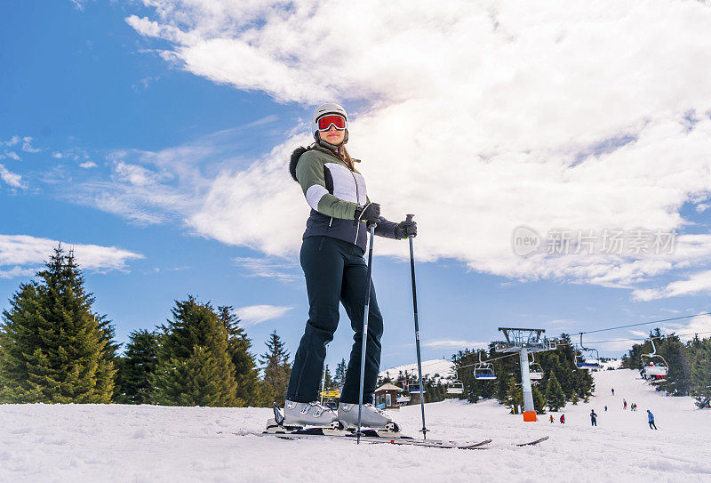 年轻活跃的女子在山上滑雪