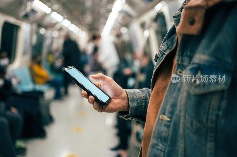 一个男人在地铁里用智能手机的特写