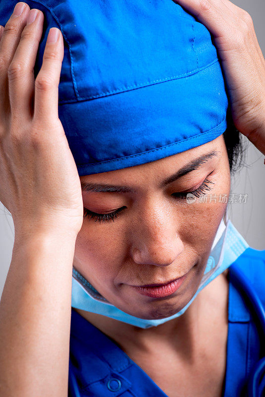 过度劳累，忧郁，紧张严肃的亚洲女性保健工作者向下看