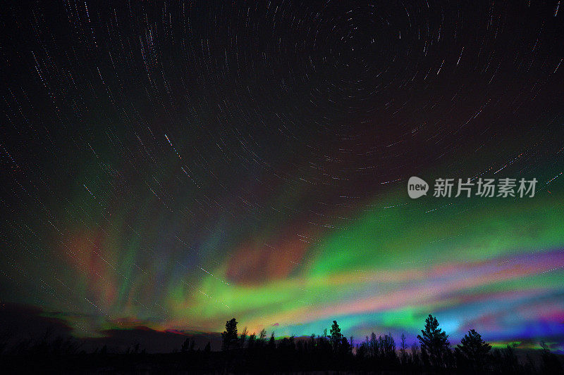 夜空中五颜六色的北极光。星星在数字生成的图像上留下痕迹