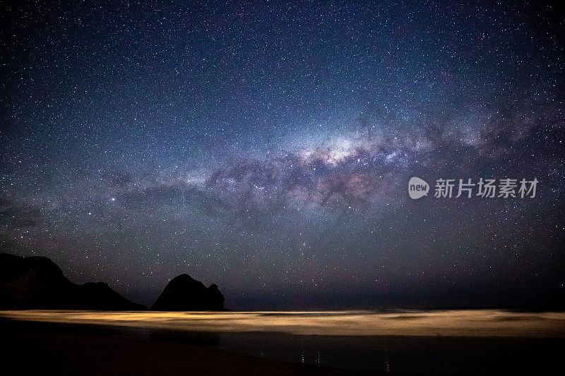 新西兰奥克兰晚上的皮哈海滩和银河星系