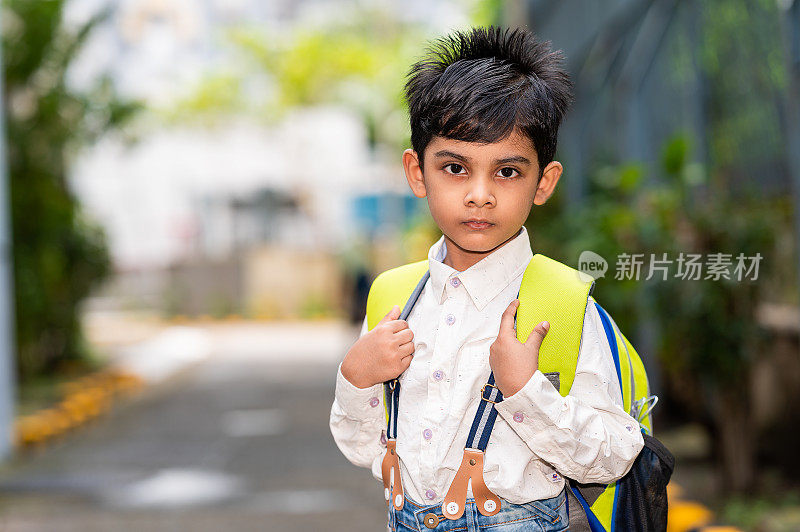 小男孩背着书包去上学。
