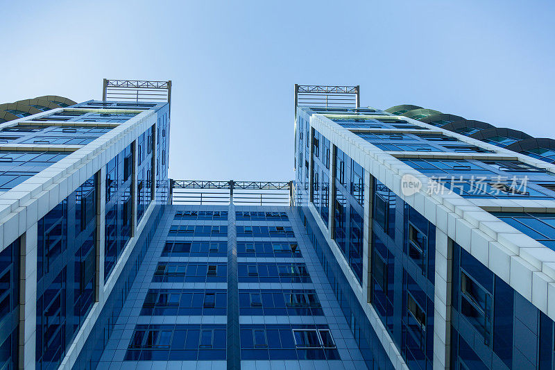 低角度看企业建筑立面的混凝土和蓝色玻璃