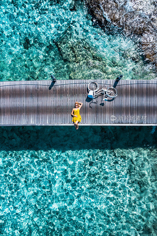 美丽的女人躺在码头与自行车在马尔代夫