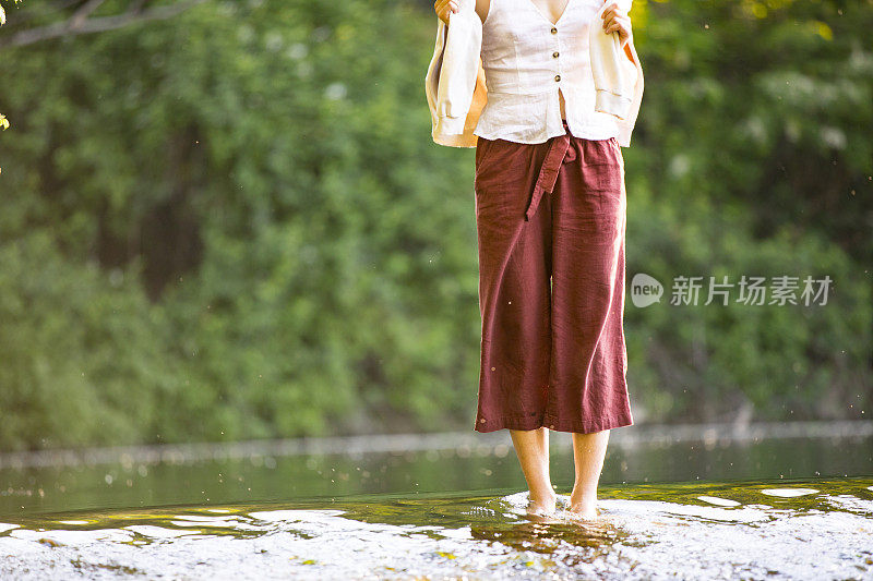 女人赤脚站在河边的低段
