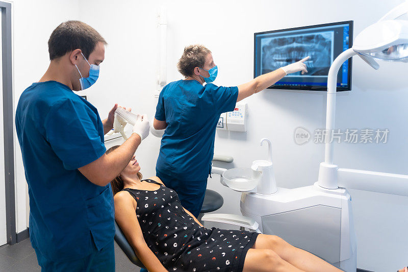 牙科诊所，一名年轻女子每年例行体检，正在看x光片