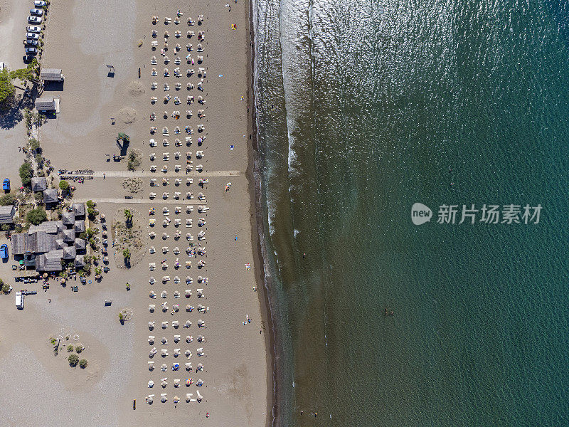 鸟瞰沙滩上的日光浴床、休息室、雨伞。夏季与旅游概念