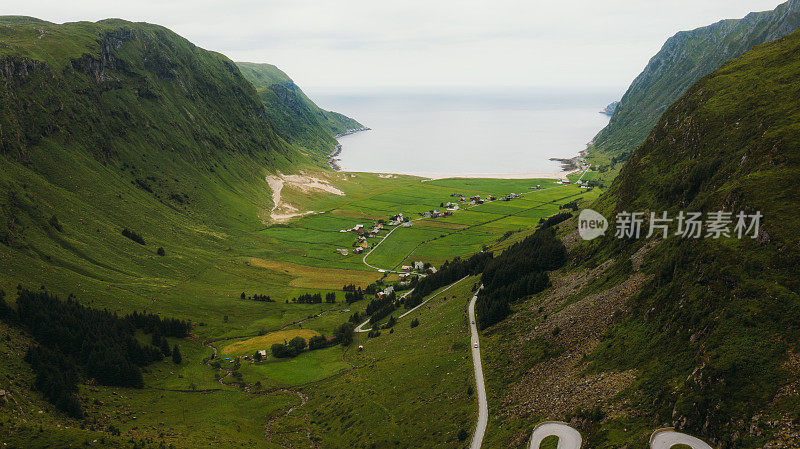 风景鸟瞰山发夹路到村庄在挪威的海边