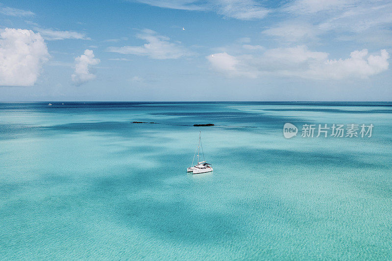 航拍双体船锚定在绿松石水域Shroud礁，埃克苏马