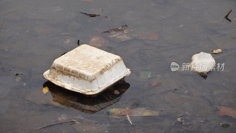 泡沫塑料垃圾，用过的食品包装被倾倒在湖岸