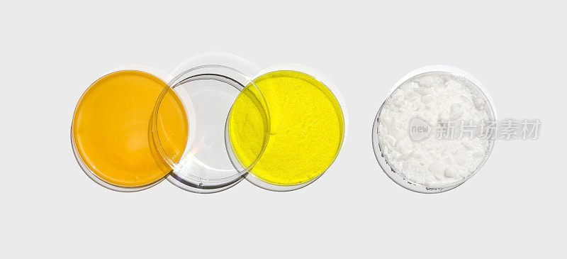 沐浴霜、铬酸钾粉、十六烷基酯蜡放入有塑料盖的培养皿中，放在白色实验台上。化妆品和洗漱用品的化学成分。俯视图