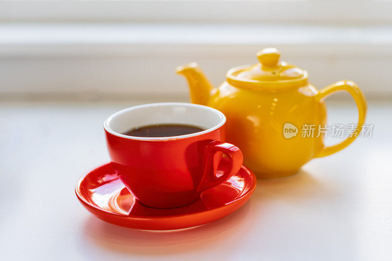 一个红茶杯和一个黄茶壶