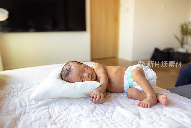 刚出生的婴儿睡在床的侧面视图