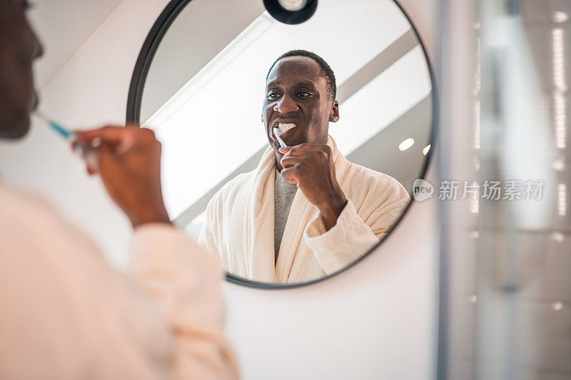 中年黑人拿着牙刷刷牙