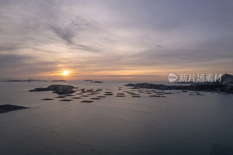 在日出的时候，海上的水产养殖场重新进入阳光下