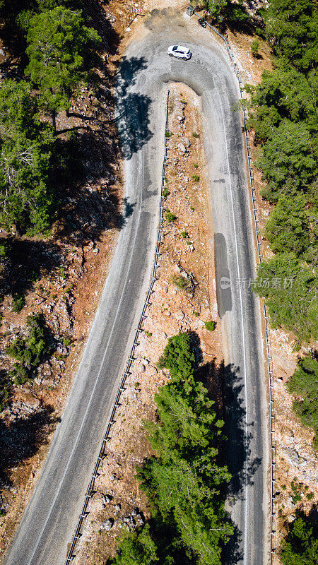 在森林山区的道路上行驶的车辆用无人机拍摄沥青弯道