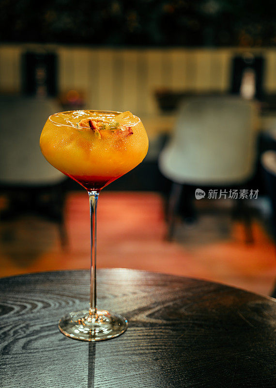 柑桔的幸福:橙色酒精鸡尾酒与白色泡沫和皮在餐厅的桌子上