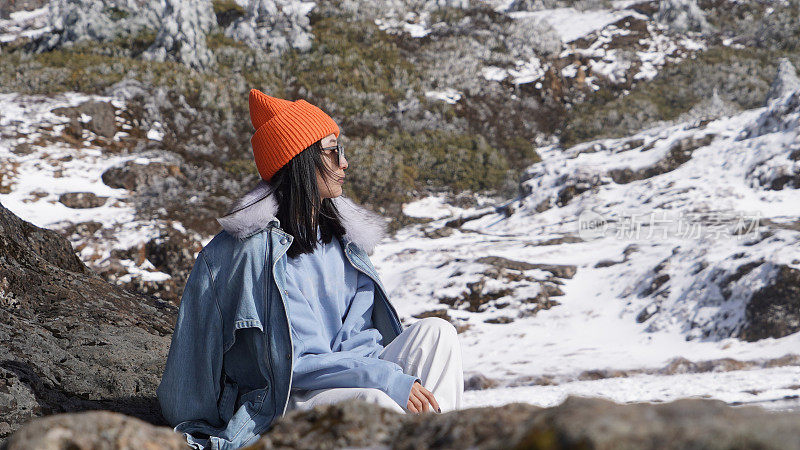 一个女人在寒冷的天气里穿行于白雪覆盖的山林之中