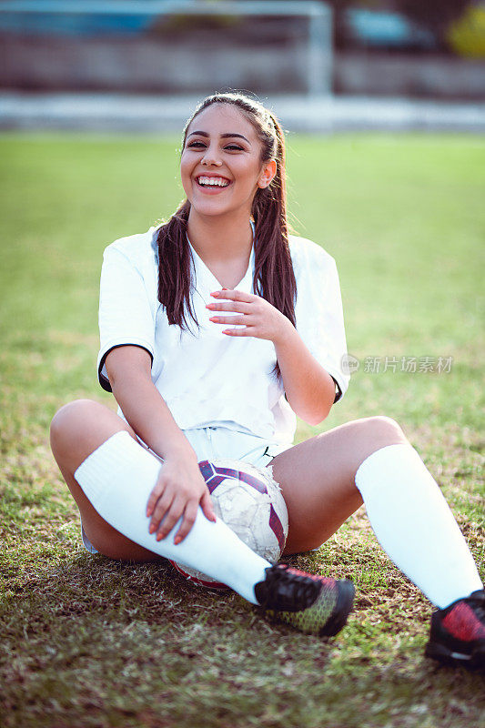 快乐的女足球运动员在休息的时候玩得很开心