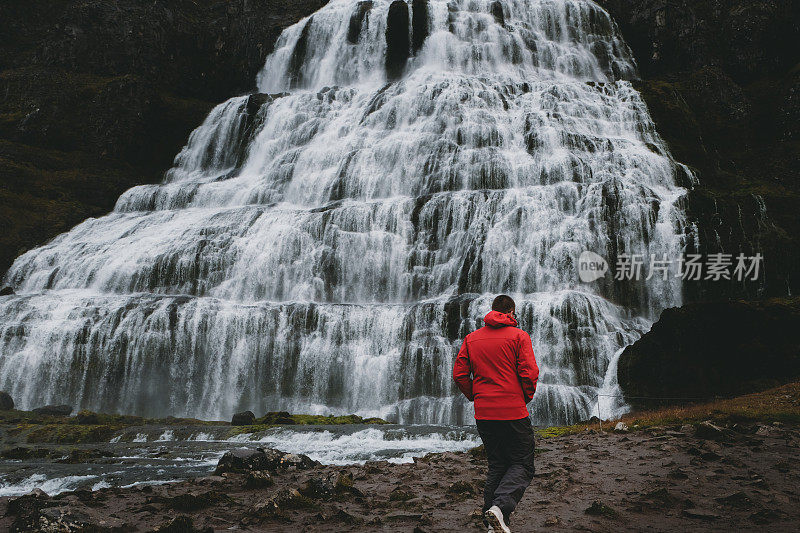 一名男子站在冰岛壮观的Dynjandi瀑布附近