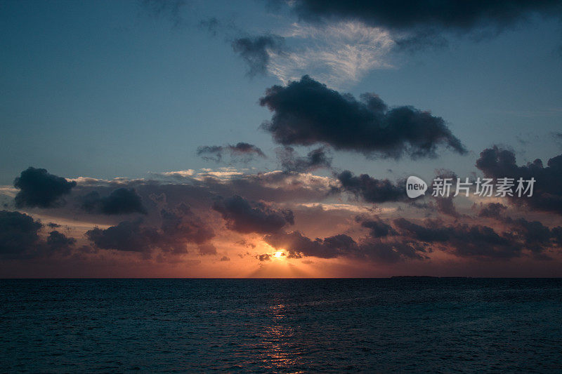 海滩上五颜六色的夕阳。多云的天空