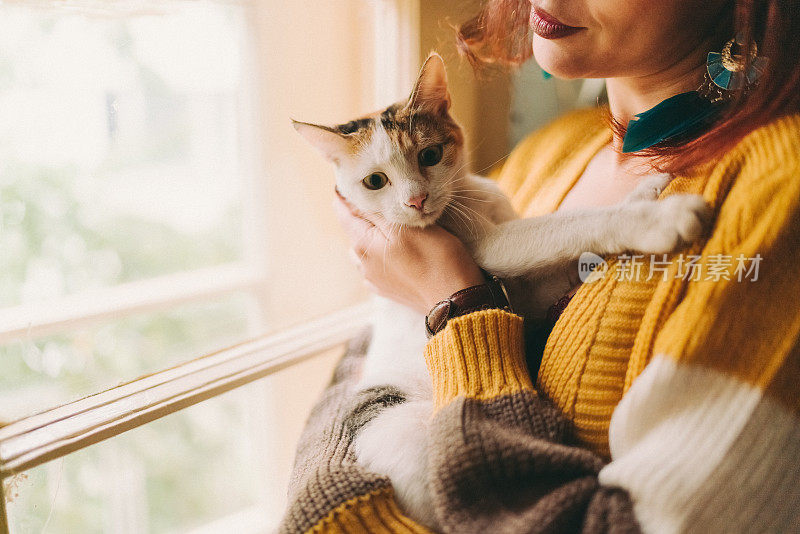 女孩和猫站在窗边