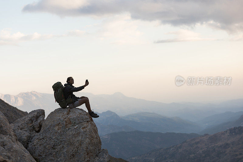 登山者在山顶使用智能手机