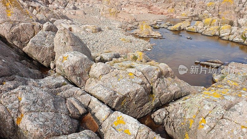 悬崖上的岩石和岩石池由红彼得黑德花岗岩制成