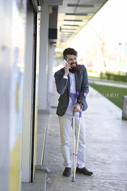 年轻漂亮的大胡子男人拄着拐杖走在街上