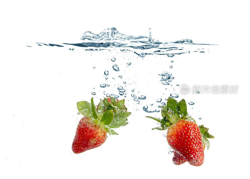 在白色的背景下，成熟的草莓溅入淡水中