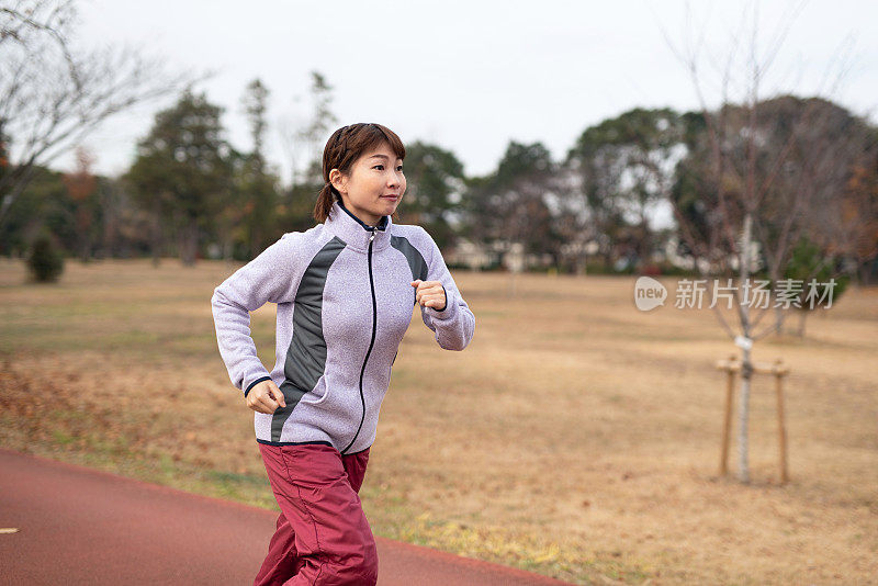 在秋天公园跑步的女人