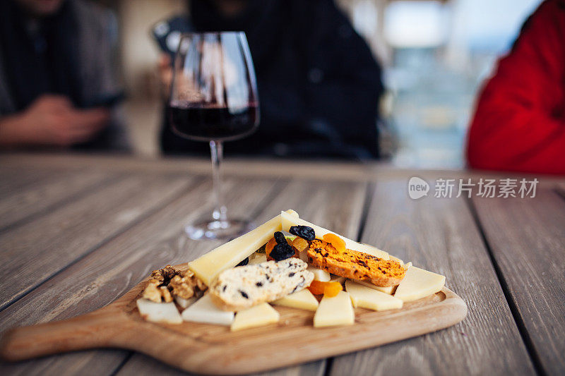 两杯玫瑰酒和木板水果，面包和奶酪在木桌库存照片