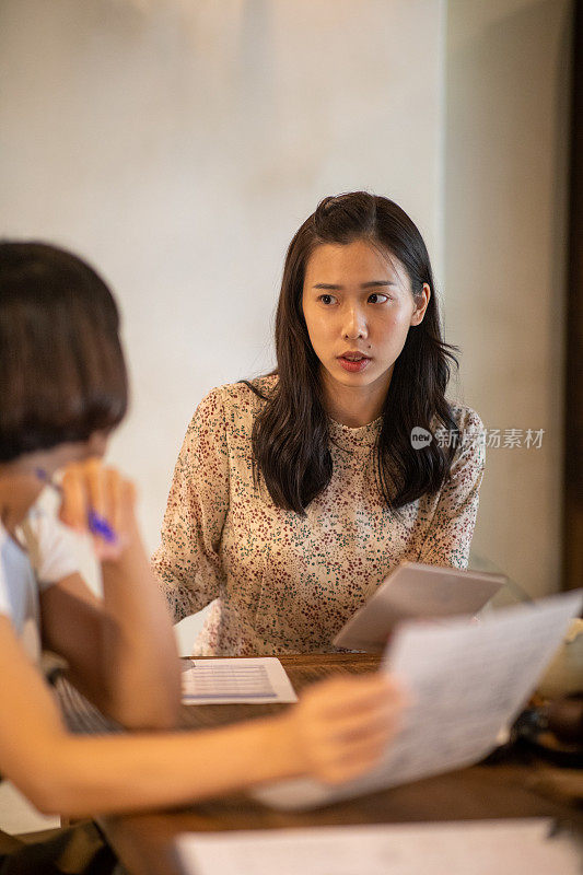 年轻的亚洲女人在咖啡馆里聊天