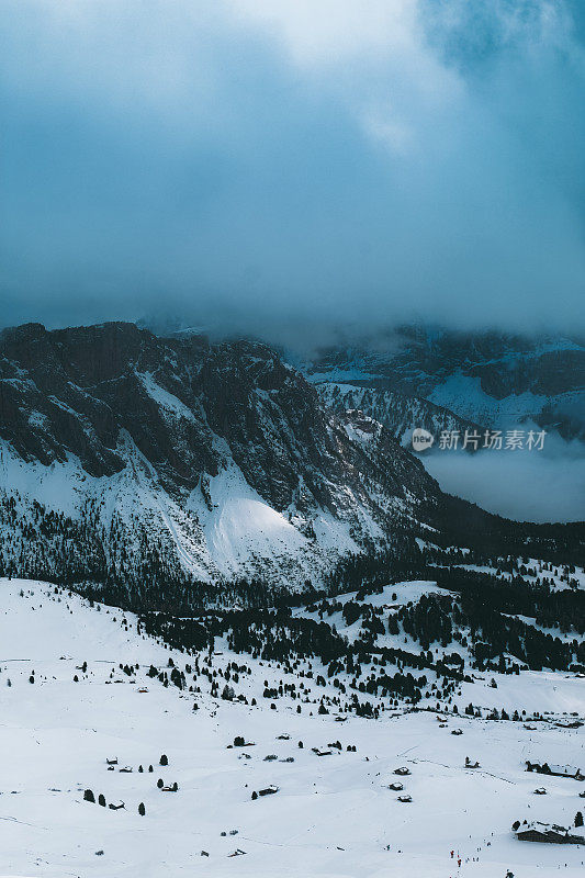 在意大利Dolomites，在蓝色的时间里，可以看到被雪覆盖的山和山上的小屋