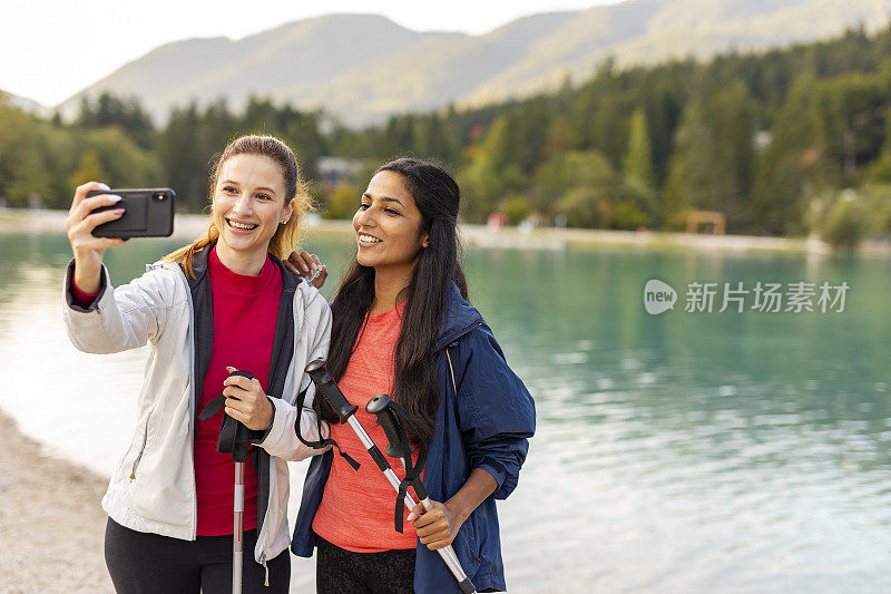 年轻女子在阿尔卑斯山徒步旅行时自拍