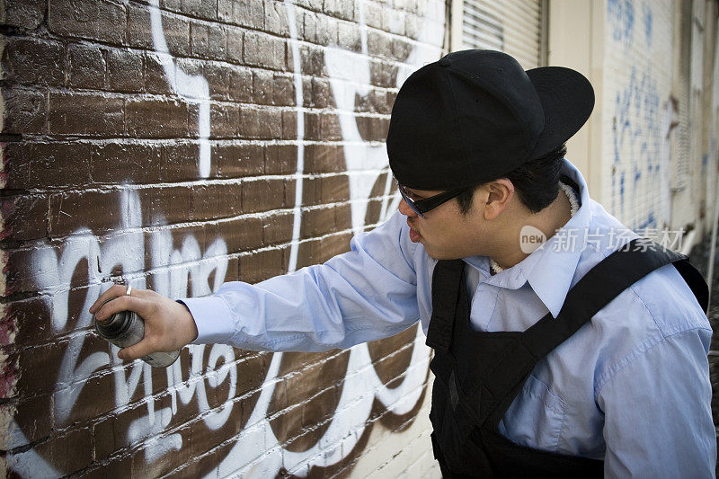 亚洲年轻人在砖墙上涂鸦，Copyspace