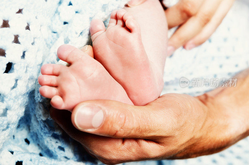 父母双手抱着新生儿的脚:太可爱了!