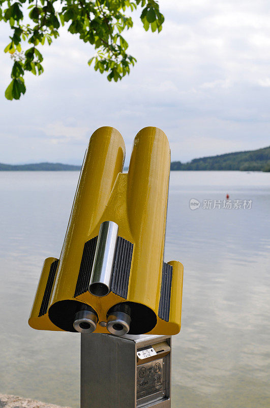 黄色双筒望远镜在一个湖前面