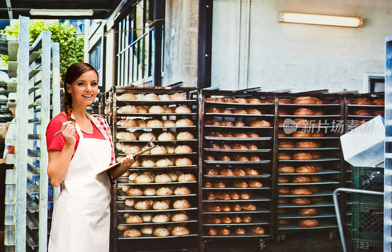 微笑的女面包师在面包店工作