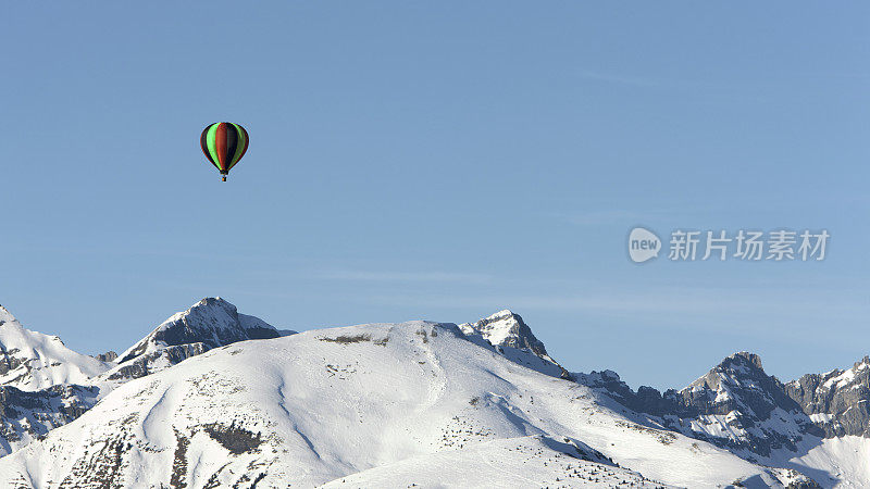 热气球在白雪覆盖的法国阿尔卑斯山上空飞行