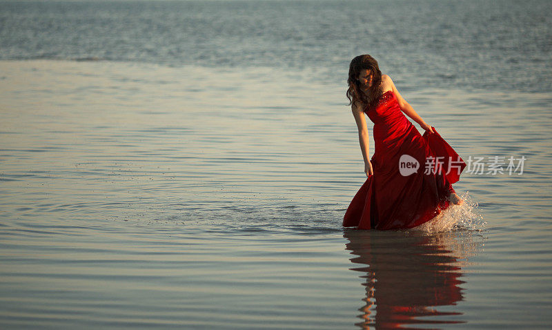 穿着红色长裙的少年在海滩上