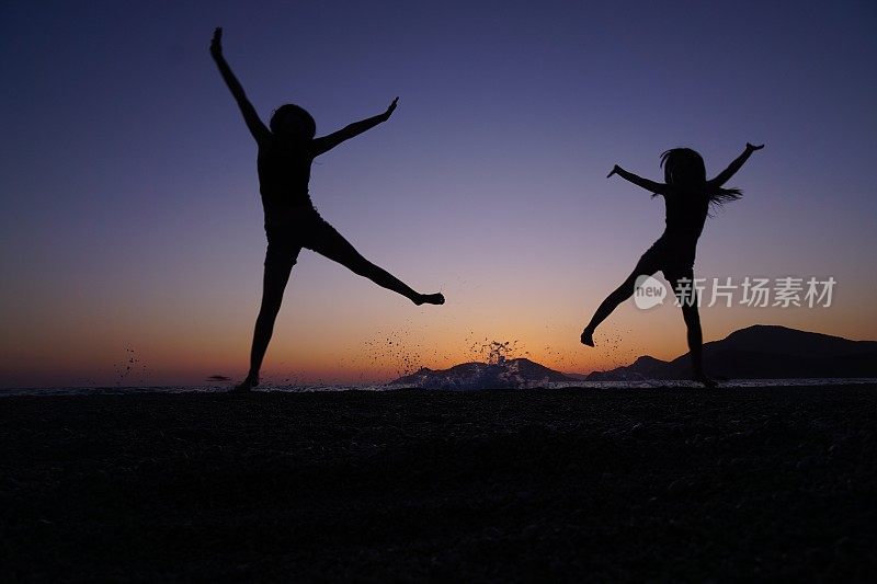 年轻女孩在海滩上跳舞。