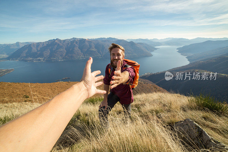 徒步旅行者在山路上帮助同伴