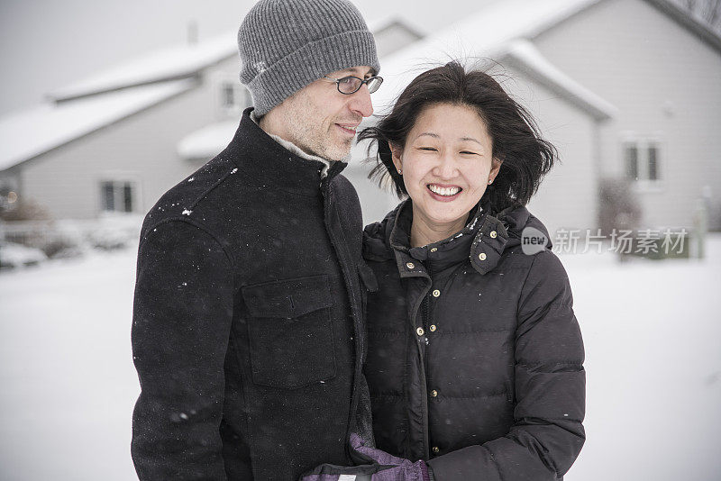多民族的夫妇在雪下享受户外的乐趣