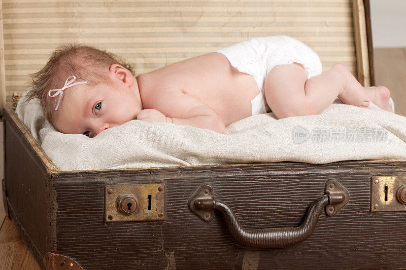 新生儿与尿布在古董手提箱