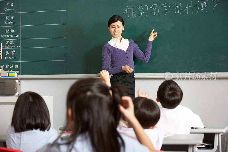 中文学校教室里，老师站在黑板旁