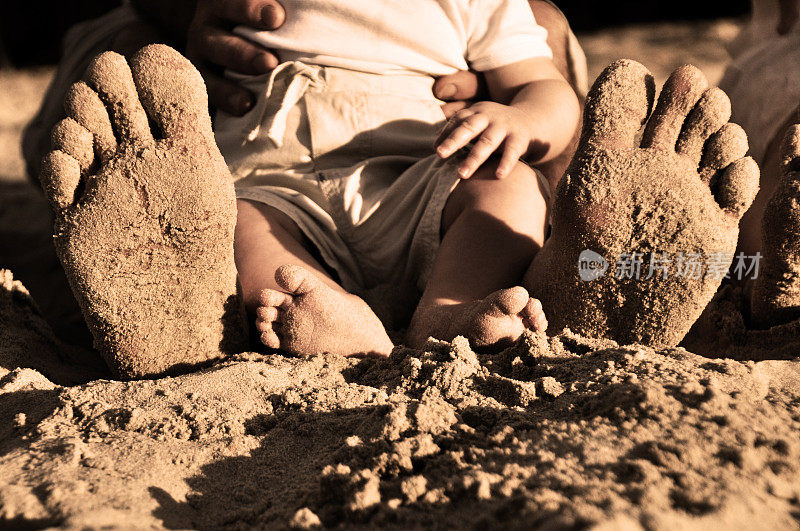爸爸和宝宝的脚在沙子里