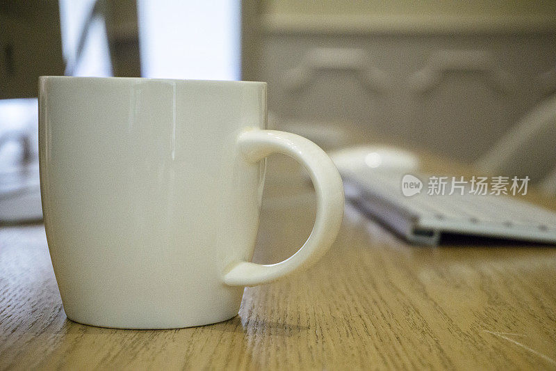 办公室桌上放着一只白瓷茶杯