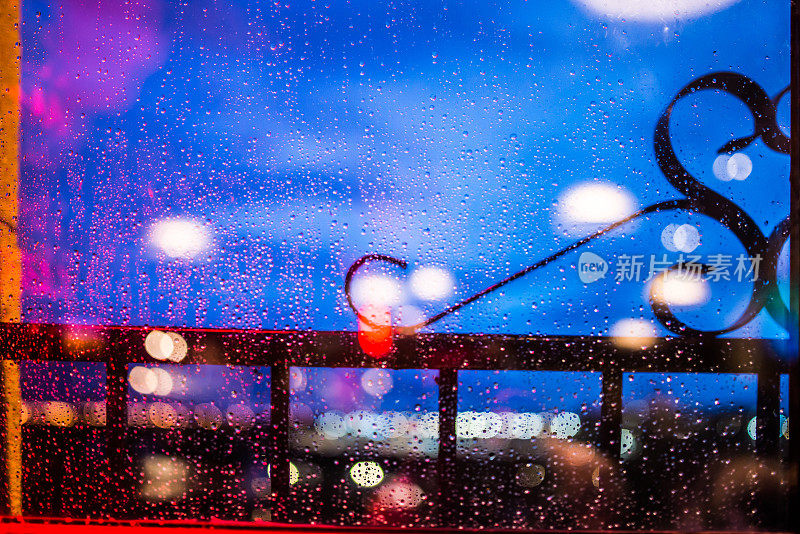 夜晚的城市灯光透过雨滴透过窗户