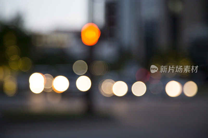 黄昏时分散焦交通十字路口五颜六色的灯光。